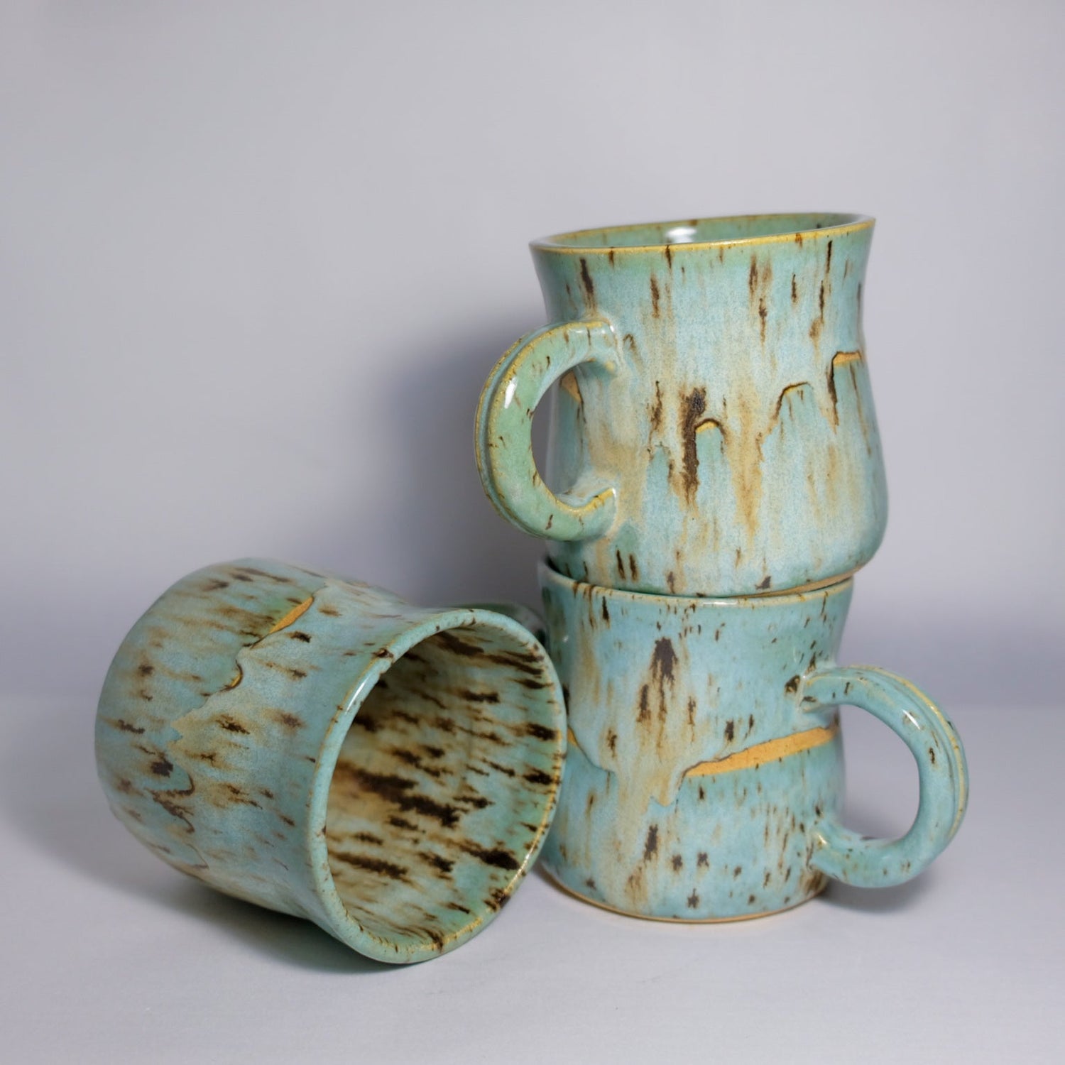 three blue mugs stacked 